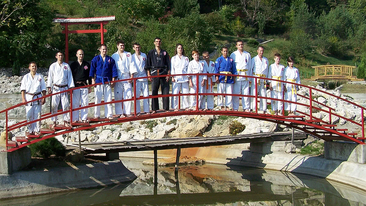 Sportivii clubului pe podul roșu din grădina japoneză